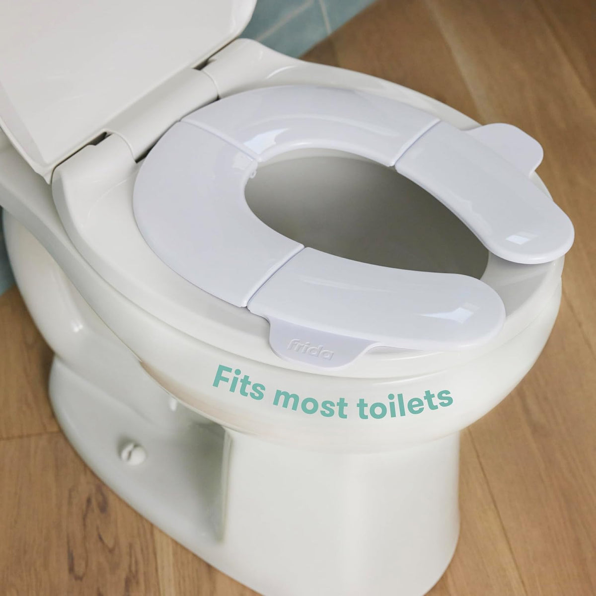 Frida Baby Fold-and-Go Portable Potty Seat for Toilet, Foldable Travel Potty Seat for Toddler, Fits Round & Oval Toilets, Non-Slip Base, Handles
